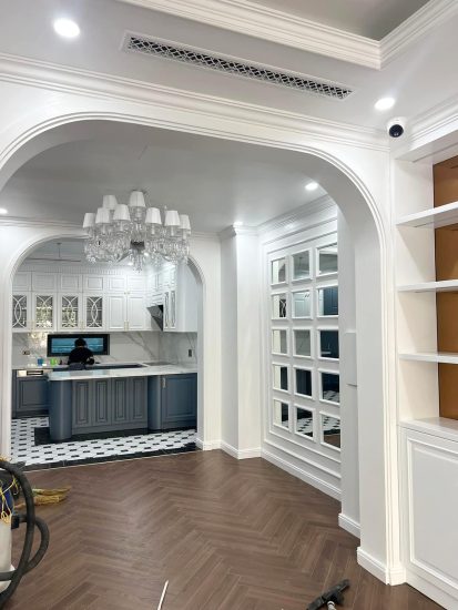 Tầm nhìn từ phòng khách qua vòm cửa cong Neo-classical sang trọng vào khu vực bếp và đảo bếp